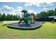 Community playground with rubber mulch surrounded by a green lawn and mature trees at 1630 Eaglerock Dr, Suwanee, GA 30024