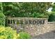 Stone community entrance sign with the 'Riverbrooke' name in metal lettering at 1630 Eaglerock Dr, Suwanee, GA 30024