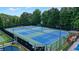 Aerial view of four well-maintained tennis courts in a community setting with green and blue surfacing at 1630 Eaglerock Dr, Suwanee, GA 30024