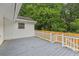 Backyard deck featuring a gray deck, white railing, and wood fence, surrounded by green trees at 2049 Phillips Dr, Atlanta, GA 30315