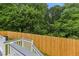 View of backyard from the back deck, showing the wood fence, lush trees and shrubbery at 2049 Phillips Dr, Atlanta, GA 30315