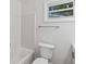 Bright bathroom with white tub, toilet, vanity, and a modern towel bar, with a window at 2049 Phillips Dr, Atlanta, GA 30315