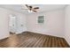 Bedroom with wood-look flooring, ceiling fan, and a view into the attached bathroom at 2049 Phillips Dr, Atlanta, GA 30315