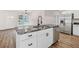 Kitchen island with gray marble countertop, stainless steel appliances, white cabinets, and black hardware at 2049 Phillips Dr, Atlanta, GA 30315