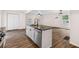 Kitchen island with stainless steel appliances, gray marble countertops, white cabinets and black hardware at 2049 Phillips Dr, Atlanta, GA 30315