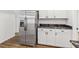 Stainless steel refrigerator adjacent to white cabinets with black hardware and gray marble countertop at 2049 Phillips Dr, Atlanta, GA 30315