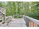 Outdoor deck with wooden planks, surrounded by a lush green forest setting at 3328 Hidden Bluff Trl, Snellville, GA 30039