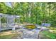 Backyard showing a dated in-ground pool with patio and a wooded backdrop at 3328 Hidden Bluff Trl, Snellville, GA 30039