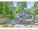 Backyard view of a gray two-story home featuring an in-ground pool and multi-level decks at 3328 Hidden Bluff Trl, Snellville, GA 30039