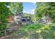Backyard view of a two story home with a wooden deck and shed surrounded by dense trees at 3328 Hidden Bluff Trl, Snellville, GA 30039