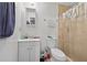 Compact bathroom featuring tiled walls, a vanity, toilet, and a shower with clear curtain at 3328 Hidden Bluff Trl, Snellville, GA 30039