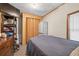 Neutral bedroom featuring a bed, storage shelving, and folding door closet at 3328 Hidden Bluff Trl, Snellville, GA 30039
