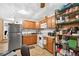 Functional kitchen featuring stainless steel appliances, wood cabinets, and metal shelving unit at 3328 Hidden Bluff Trl, Snellville, GA 30039