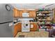 Well-lit kitchen with wood cabinets, stainless steel refrigerator, and practical shelving for ample storage at 3328 Hidden Bluff Trl, Snellville, GA 30039
