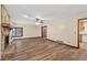 Inviting living room with vinyl floors, fan, and stone fireplace, with an adjacent entry to a kitchen at 3328 Hidden Bluff Trl, Snellville, GA 30039