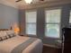 Comfortable bedroom featuring soft lighting, neutral wall colors, and two windows for plenty of natural light at 505 Appalachian Woods Dr, Canton, GA 30114