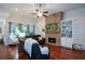Inviting living room with stone fireplace, built-in shelving, hardwood floors, and a ceiling fan at 505 Appalachian Woods Dr, Canton, GA 30114