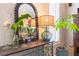 Stylish console table featuring decorative mirror, lamp, and plants near window with modern blinds at 6426 Queens Court Trce # 7, Mableton, GA 30126