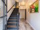 Inviting foyer with hardwood floors, elegant lighting, black staircase, and unique artwork for a stylish entrance at 6426 Queens Court Trce # 7, Mableton, GA 30126