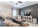 Comfortable living room features a large sectional, whitewashed brick wall, and modern decor at 6426 Queens Court Trce # 7, Mableton, GA 30126