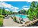 Community swimming pool surrounded by mature trees, lounge chairs and tables with umbrellas at 6426 Queens Court Trce # 7, Mableton, GA 30126