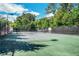 Outdoor tennis court surrounded by lush greenery and tall fences, perfect for recreational play at 6426 Queens Court Trce # 7, Mableton, GA 30126