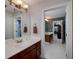 Ensuite bathroom with a white sink, wood cabinets, a mirror, and a door into the bonus room at 1000 Collingtree Ct, Mcdonough, GA 30253
