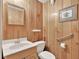 Clean bathroom with a white toilet and sink complemented by wood-paneled walls at 2020 Ridge Gate Drive Dr, Cumming, GA 30041