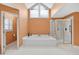Bright bathroom featuring a tub, shower with gold trim, and a large vaulted window at 2020 Ridge Gate Drive Dr, Cumming, GA 30041