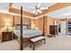 Spacious bedroom featuring a four-poster bed, bedside tables, tray ceiling and ensuite closet at 2020 Ridge Gate Drive Dr, Cumming, GA 30041