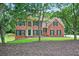 Charming brick home with manicured lawn and mature trees offering a picturesque setting at 2020 Ridge Gate Drive Dr, Cumming, GA 30041