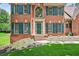 Close-up of the brick facade with large windows and decorative shutters, enhancing the home's curb appeal at 2020 Ridge Gate Drive Dr, Cumming, GA 30041