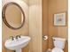 Clean half bathroom with pedestal sink, oval mirror, and updated fixtures at 2020 Ridge Gate Drive Dr, Cumming, GA 30041