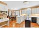 Bright kitchen with white cabinets, a black island, and hardwood floors at 2020 Ridge Gate Drive Dr, Cumming, GA 30041