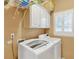 Convenient laundry room featuring modern appliances, storage cabinets, and a window with shutters at 2020 Ridge Gate Drive Dr, Cumming, GA 30041