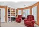 Comfortable living room with two plush armchairs, built-in shelving, fireplace and multiple windows at 2020 Ridge Gate Drive Dr, Cumming, GA 30041