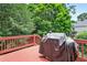 A grill sitting on a stained red deck, perfect for outdoor cooking and entertaining at 2020 Ridge Gate Drive Dr, Cumming, GA 30041