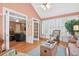 Comfortable sunroom with hardwood floors, wicker furniture, and views to the living room at 2020 Ridge Gate Drive Dr, Cumming, GA 30041