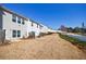 The back of several townhomes, showcasing yards and white picket fences against a clear blue sky at 2873 Snapfinger Mnr, Decatur, GA 30035