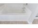 Close-up of a white bathtub with neutral tile floors and walls at 2873 Snapfinger Mnr, Decatur, GA 30035