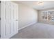 This carpeted bedroom offers a neutral color scheme, lots of light, and a large window at 2873 Snapfinger Mnr, Decatur, GA 30035