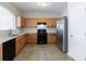 Bright kitchen with wood cabinets, black appliances, and a stainless steel refrigerator at 2873 Snapfinger Mnr, Decatur, GA 30035