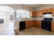The kitchen features wood cabinets and black appliances, with a view into the dining and living areas at 2873 Snapfinger Mnr, Decatur, GA 30035