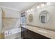 Bathroom boasting granite countertop, double sinks, soaking tub, and tile surround at 11302 Musette Cir, Alpharetta, GA 30009