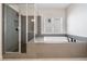 Modern bathroom featuring a luxurious tub and glass-enclosed shower at 117 Villanueva Rd, Woodstock, GA 30188