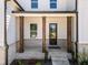 Inviting front porch with classic columns and brick accents, leading to an elegant front door at 117 Villanueva Rd, Woodstock, GA 30188