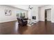 Comfortable living room with a stone fireplace, large windows, and hardwood floors at 117 Villanueva Rd, Woodstock, GA 30188