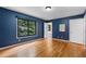 Spacious bedroom featuring hardwood floors, blue accent wall, and large window offering natural light at 2311 Sims Ne Dr, Marietta, GA 30066