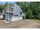 Exterior view of a blue home with a walkout basement, multi-level deck, three car garage and yard at 2311 Sims Ne Dr, Marietta, GA 30066