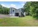 Exterior view of a blue home with a walkout basement, multi-level deck, three car garage and yard at 2311 Sims Ne Dr, Marietta, GA 30066